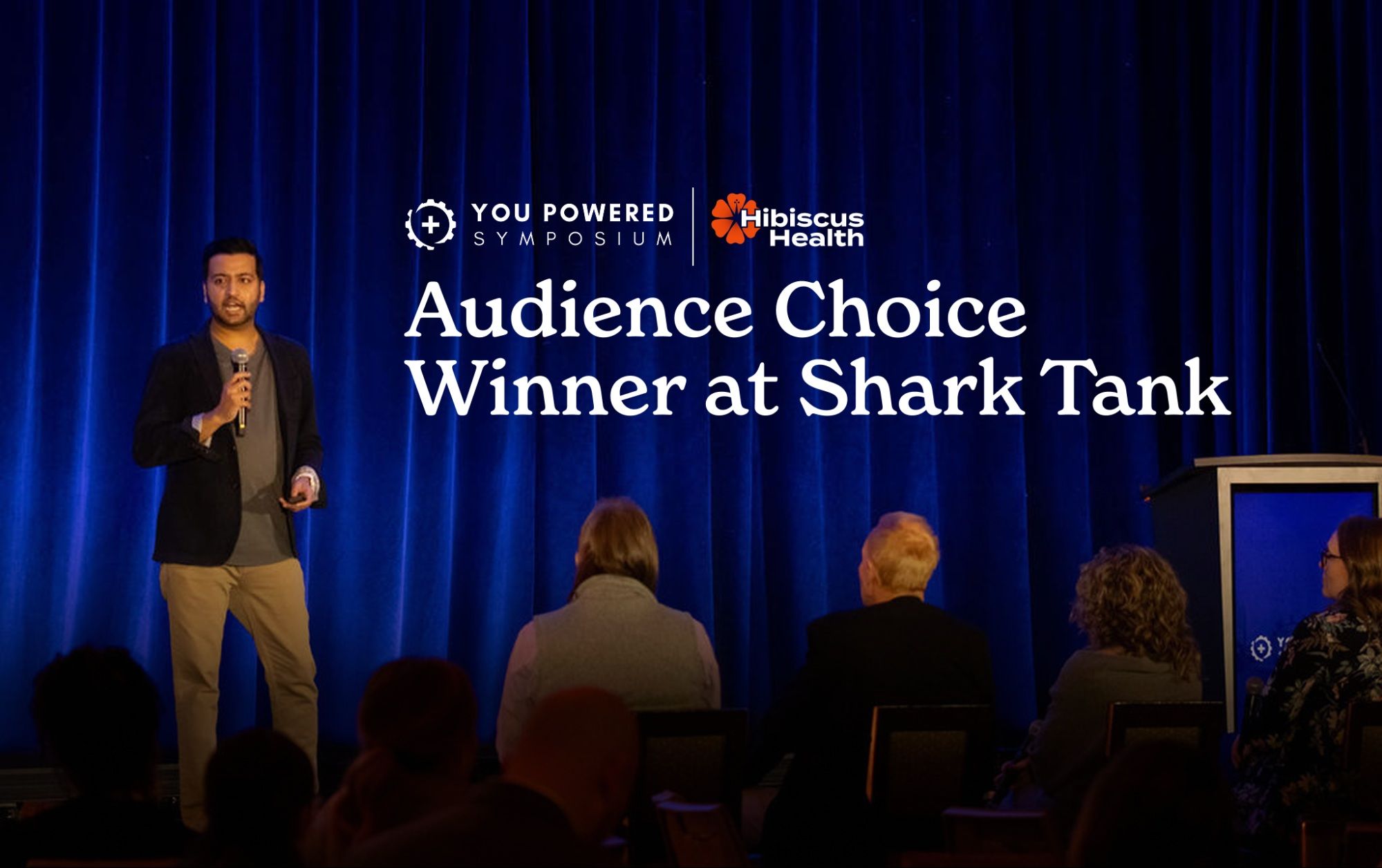 Kavi Misri on stage as Audience Choice winner at the YOU Powered Symposium Shark Tank